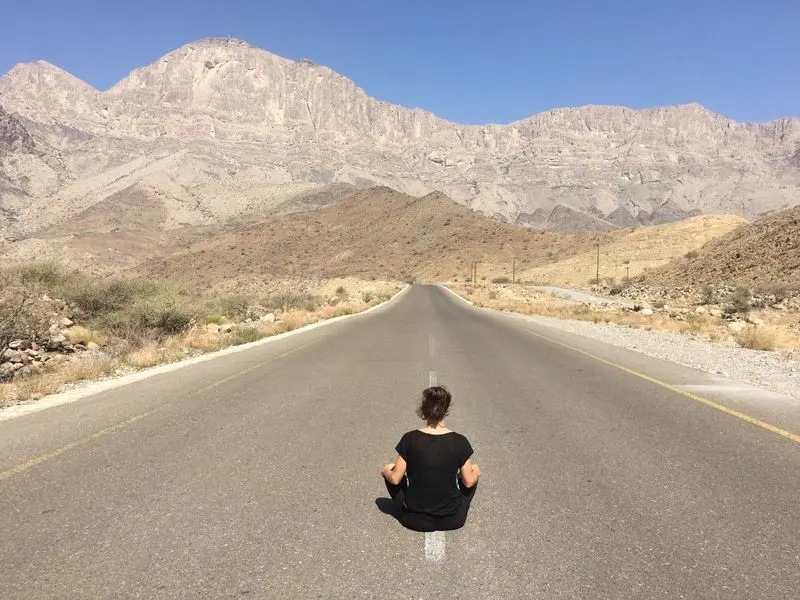 Empty road in Oman with the Jebel Shams Mountains in the background