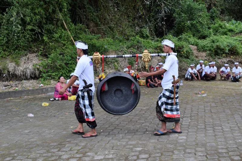 Balinese men carrying traditional gong